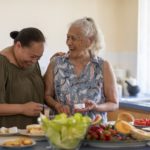 Senior Pacific Islander woman and her mature daughter preparing food together in their kitchen at home.