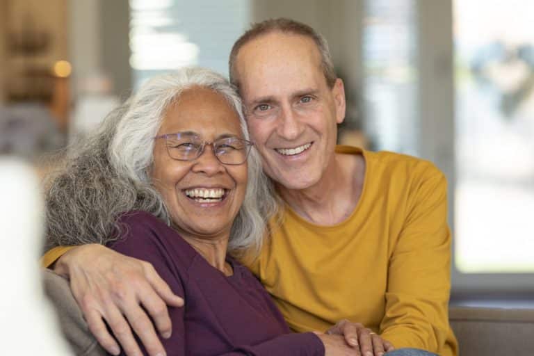 Portrait of a vibrant senior couple embracing while relaxing together at home.