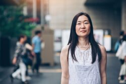 Portrait of a middle aged Japanese woman standing outdoors with arms crossed