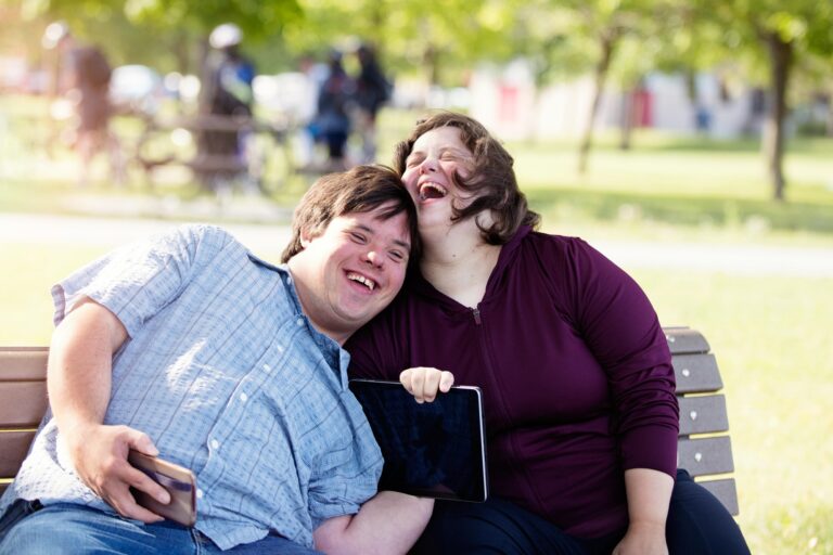 Couple in love of 26 years old Down Syndrome in a park in Montreal doing selfie with mobile phone. They are learning to live independently. Color and horizontal photo was taken in Quebec Canada.
