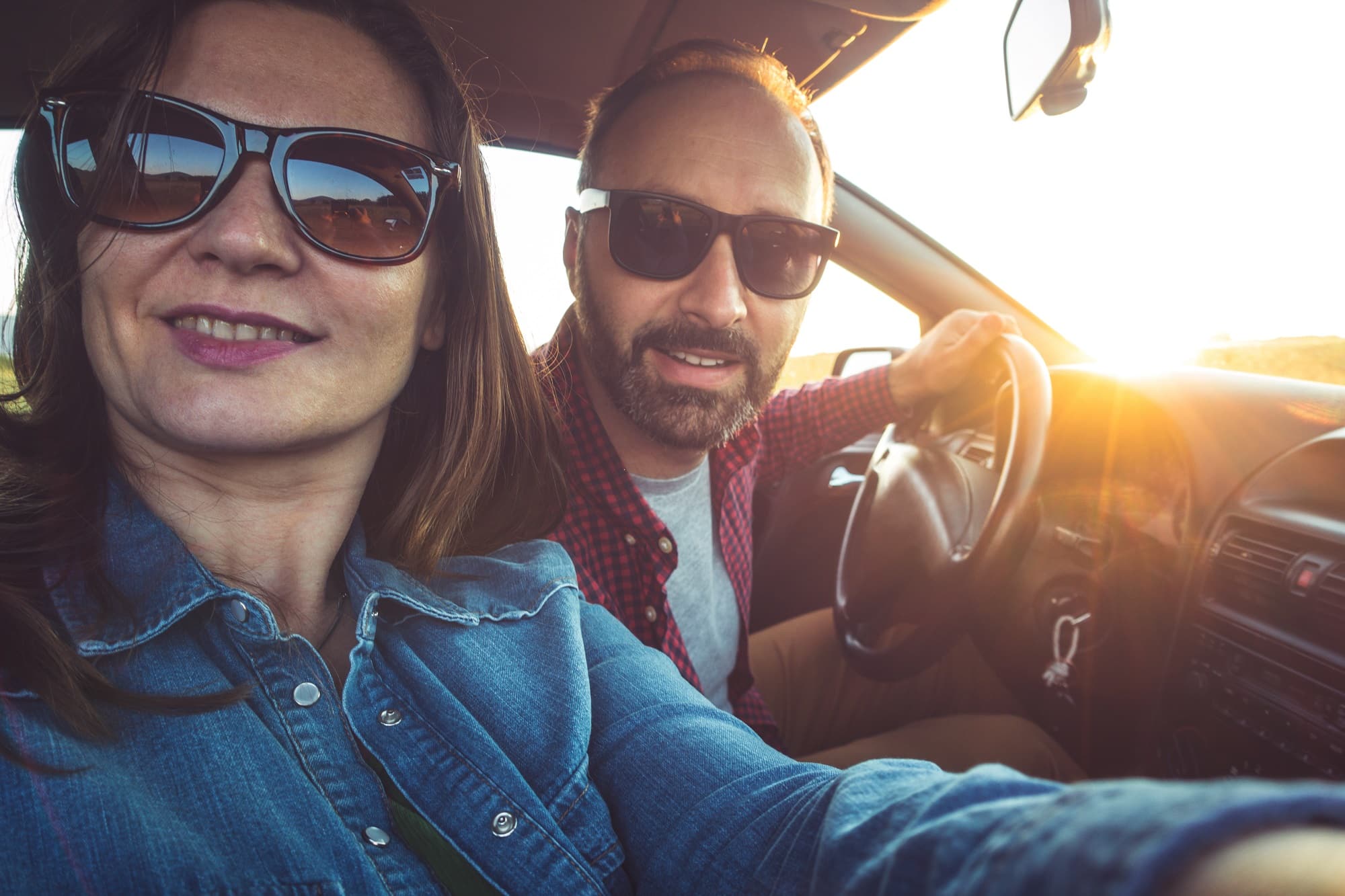 Photo of the couple traveling in the car taking selfie