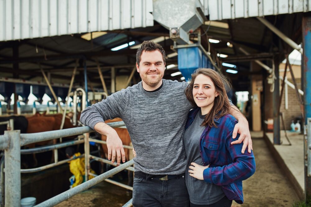 Portrait of a happy young couple working on a dairy farm