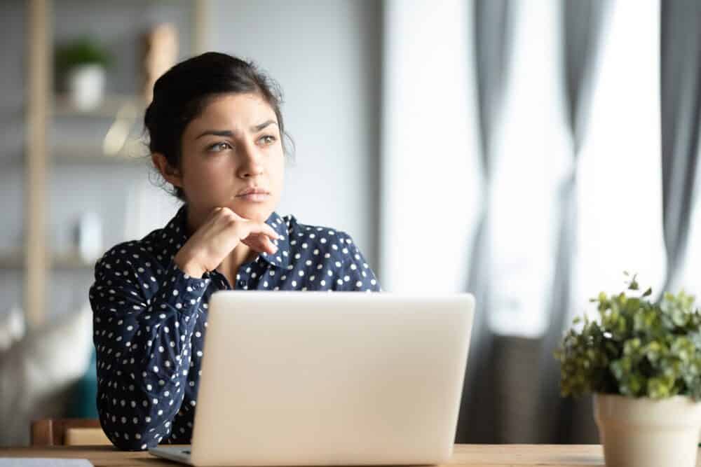 Woman thinking at her computer